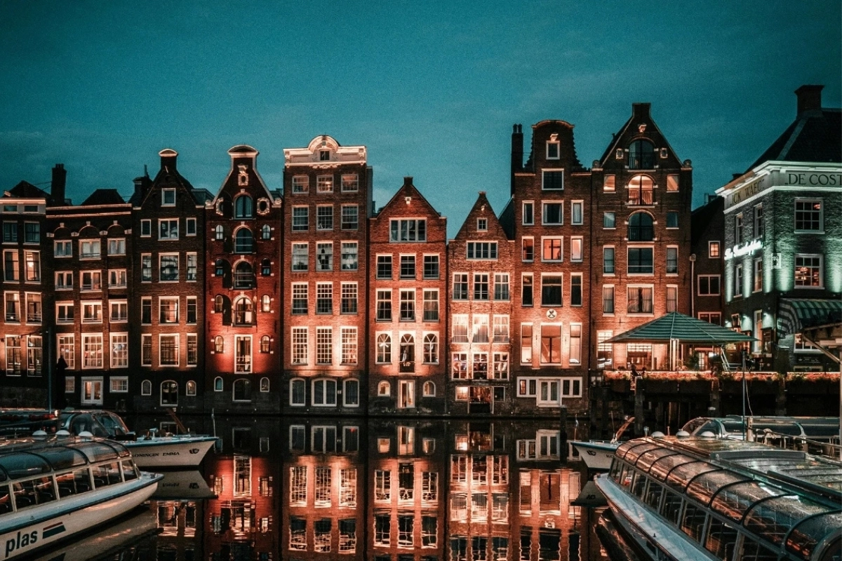 Amsterdam canal houses reflected in the water at dusk